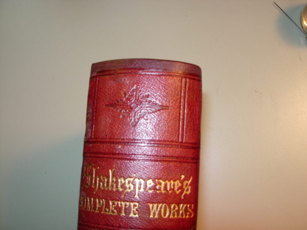 A red book with the words shakespeare 's complete works written on it.