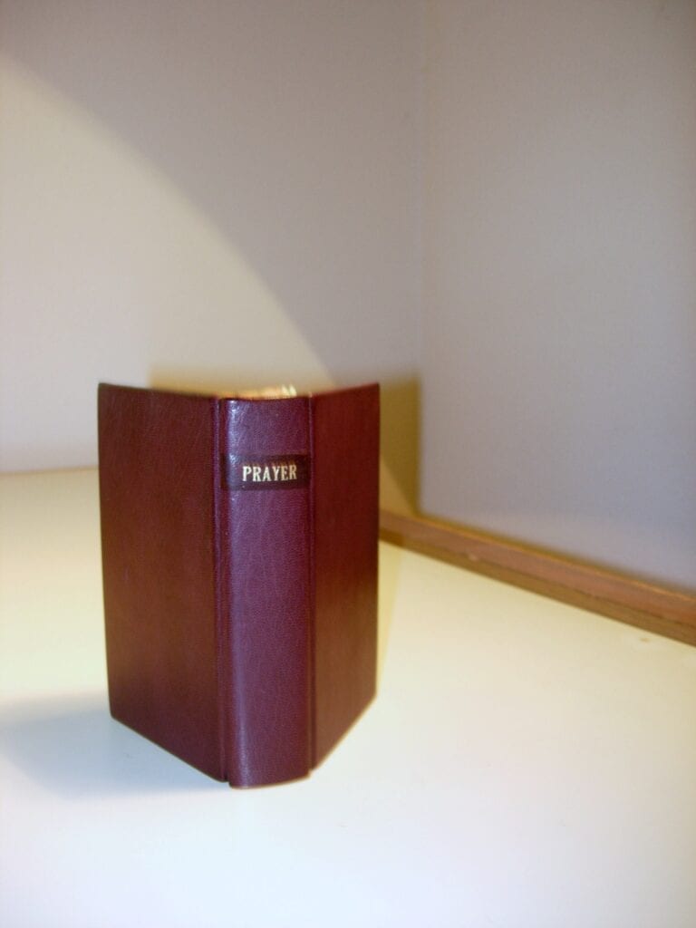 A book is sitting on the table in front of a wall.